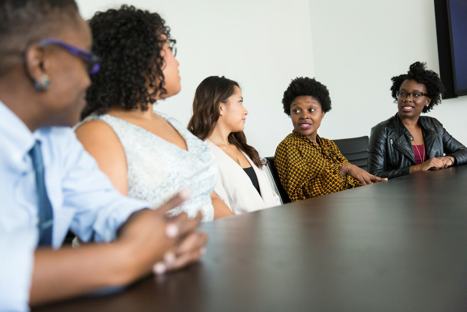 Five professionals sitting at a table discussing a case